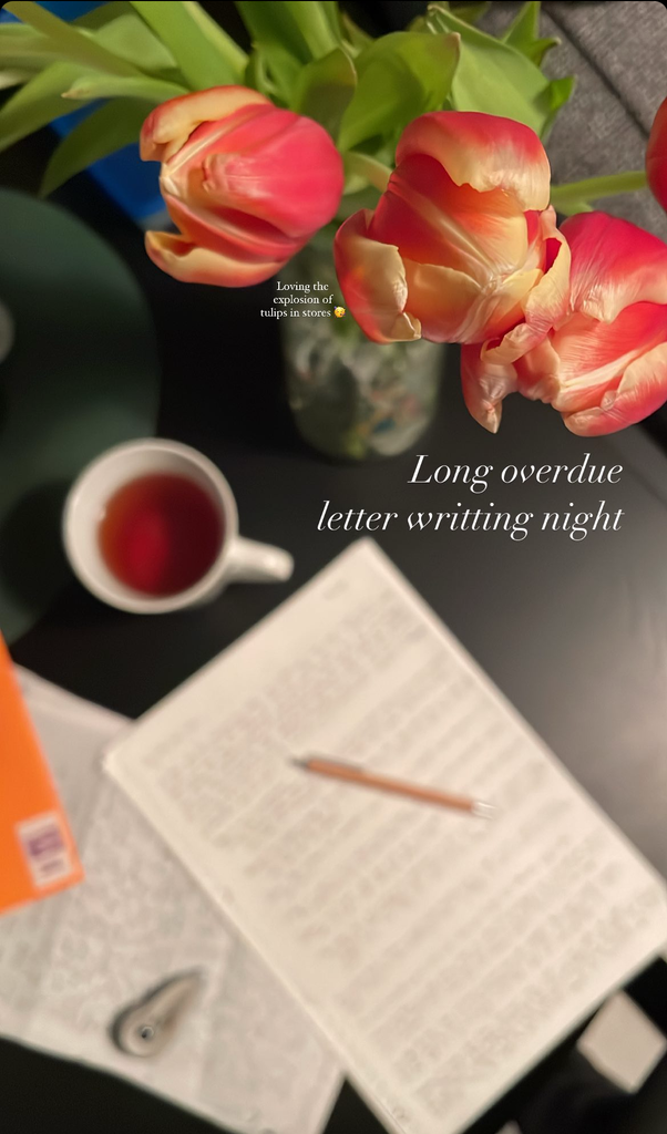 Photograph of flowers, a hand written letter and a cup of coffee.